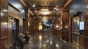 A hotel lobby with a polished marble floor, a grand chandelier, and traditional decor including lion statues. - Des Lux Hotel (Des Moines)