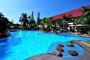 Una piscina al aire libre, sombrillas, tumbonas