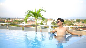 Una piscina al aire libre, sillones reclinables de piscina