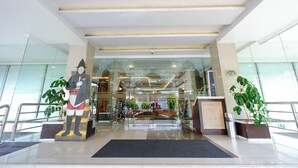 A hotel lobby with a large statue, glass walls, and a reception desk. - Pandanaran Prawirotaman Yogyakarta (Yogyakarta)