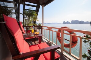 Eine Terrasse mit roten Sitzgelegenheiten, einem Tisch mit Getränken und einem Rettungsring.