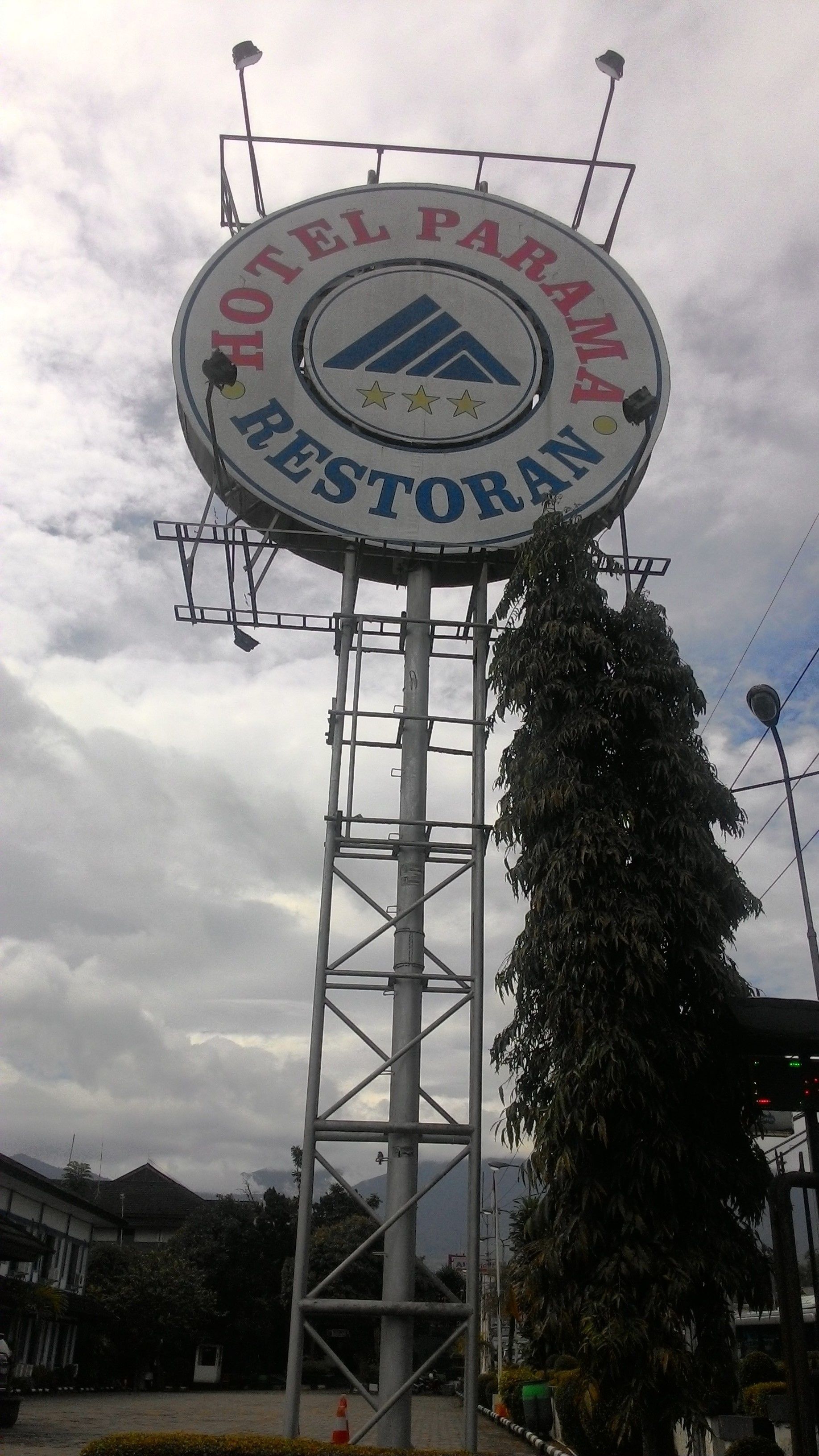 A large circular sign for Hotel Parana Restaurante, mounted on a metal structure.