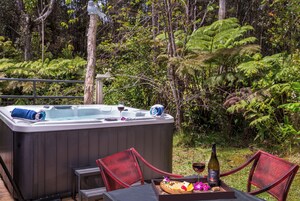 Un jacuzzi con mesa y sillas en un exuberante jardín.