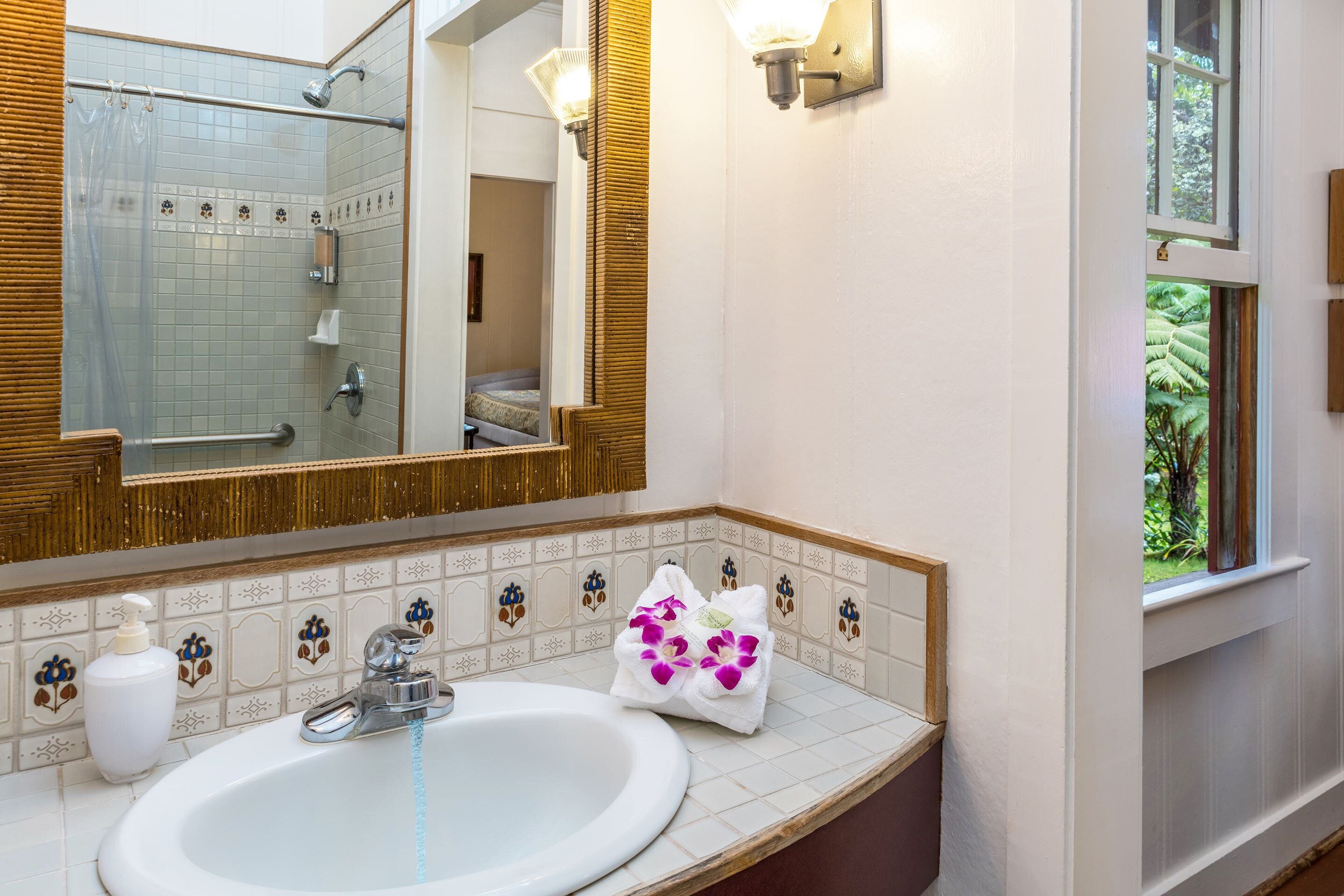 A bathroom with a white sink, a mirror, and a shower.