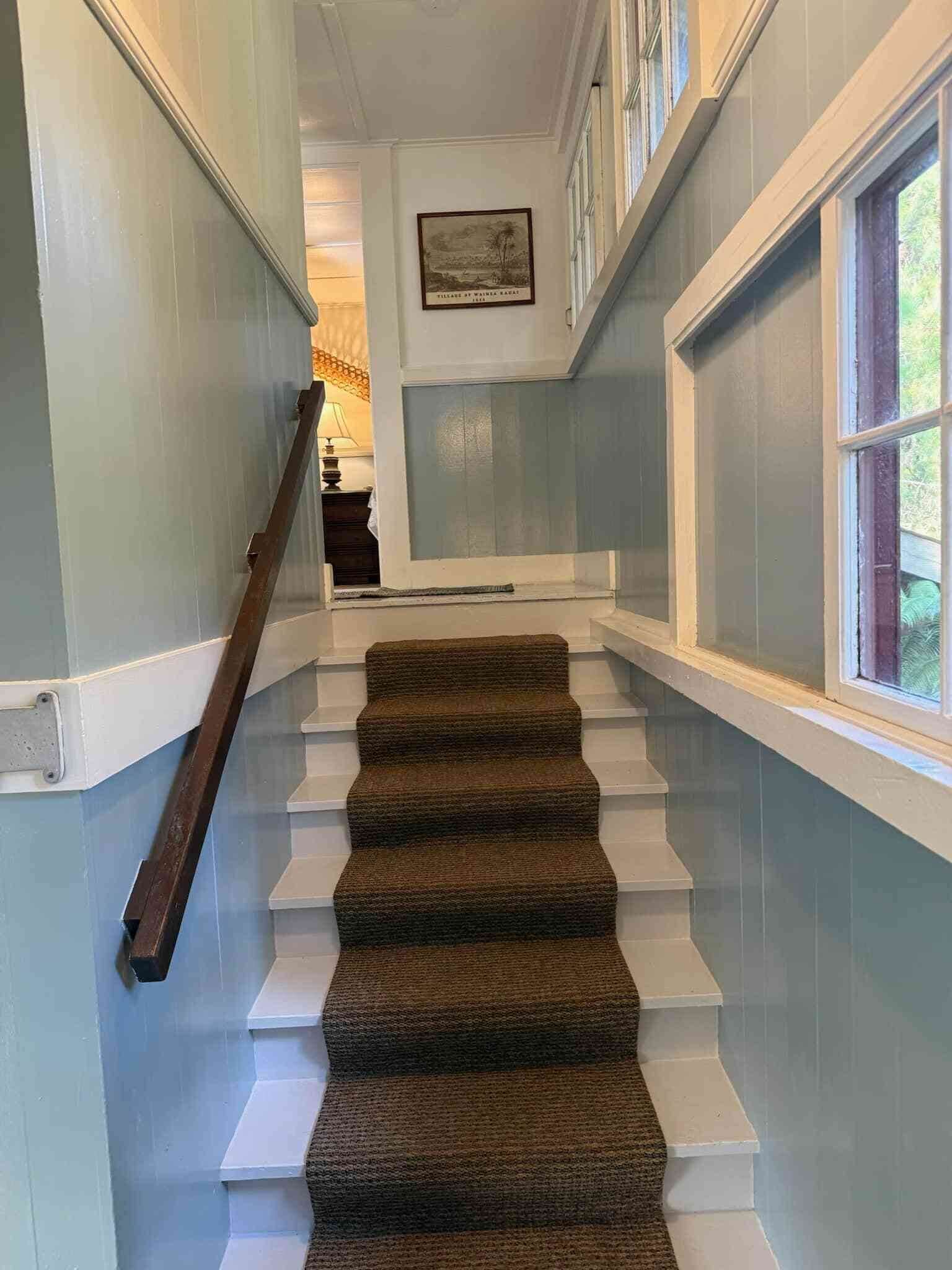 A staircase with carpeted steps leading to a landing.