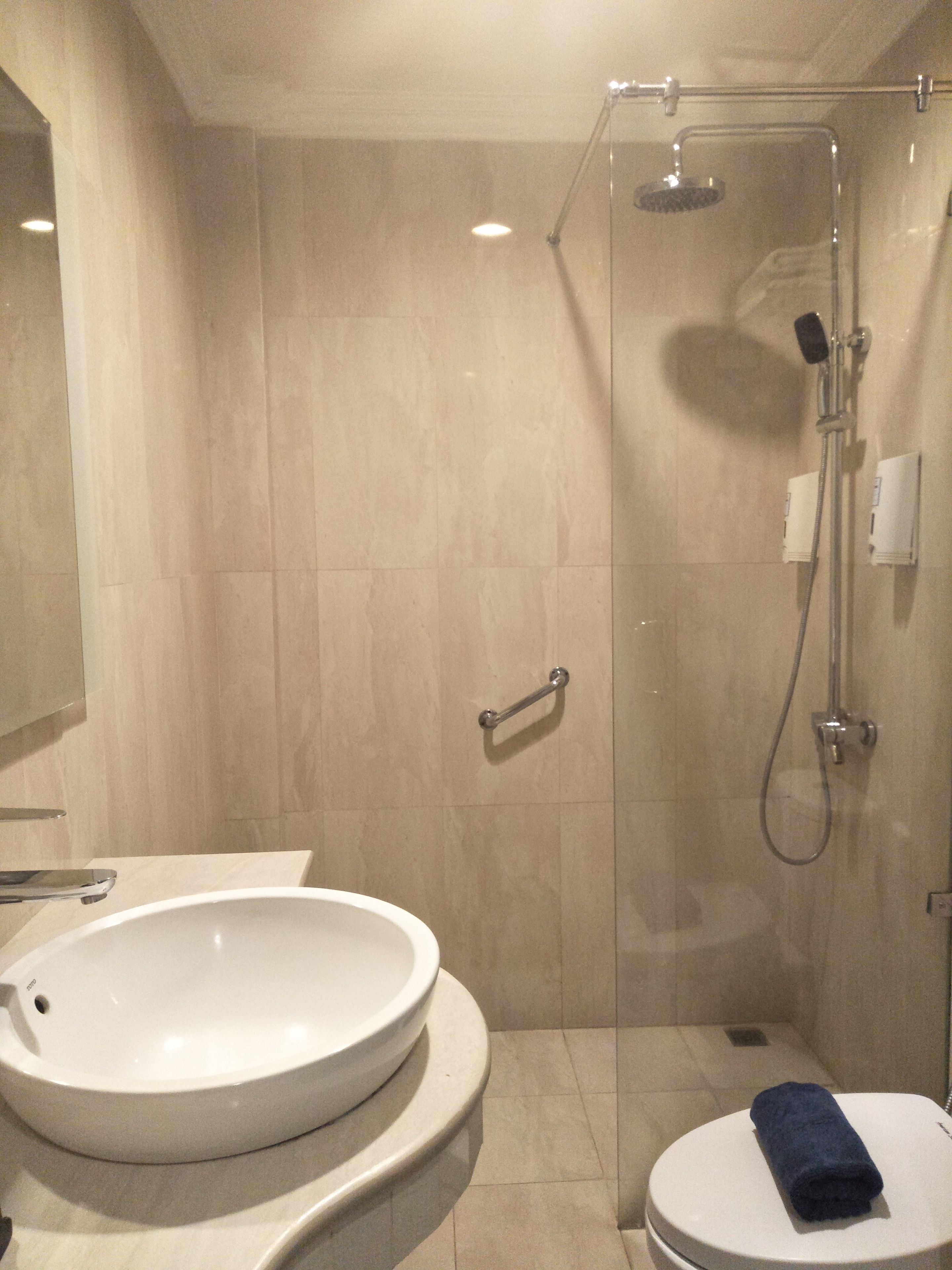 A bathroom with a large sink, toilet, and glass-enclosed shower.