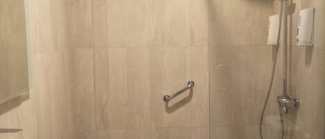 A bathroom with a large sink, toilet, and glass-enclosed shower.
