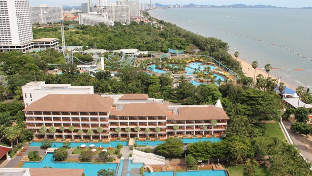 A hotel with multiple swimming pools, a beach, and a city skyline in the background. - View Talay 3 Beach Apartments (Pattaya)