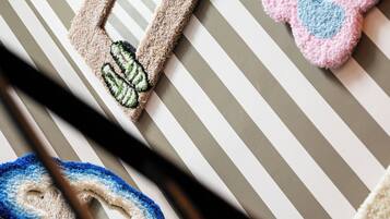 A striped fabric with embroidered patches, including a red arrow and a blue and pink design.