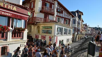 A bustling street with a restaurant named "RTHA" and a sign for "Entree dans l'Adventure."