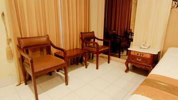 Relax in a traditionally designed room with a comfortable bed, leather-upholstered chair, and stool.