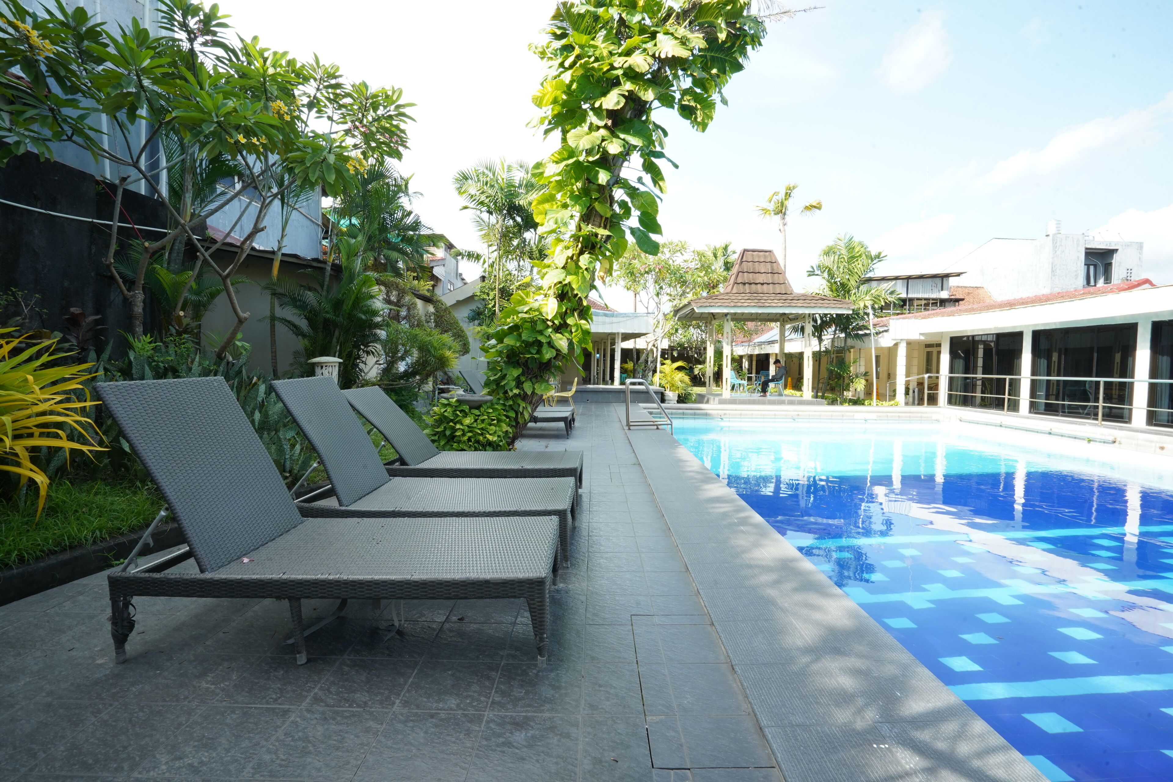 Área da piscina com espreguiçadeiras e piscina.