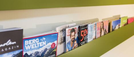 Una hilera de revistas en un estante, incluyendo títulos como 'BERG WELTEN' y 'Hotelit'.