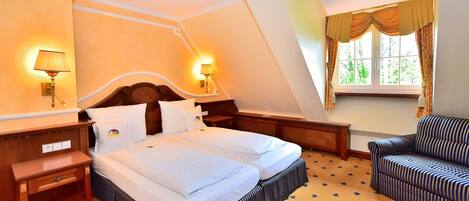 A bedroom with a bed, bedside tables, a chair, and a window with curtains.