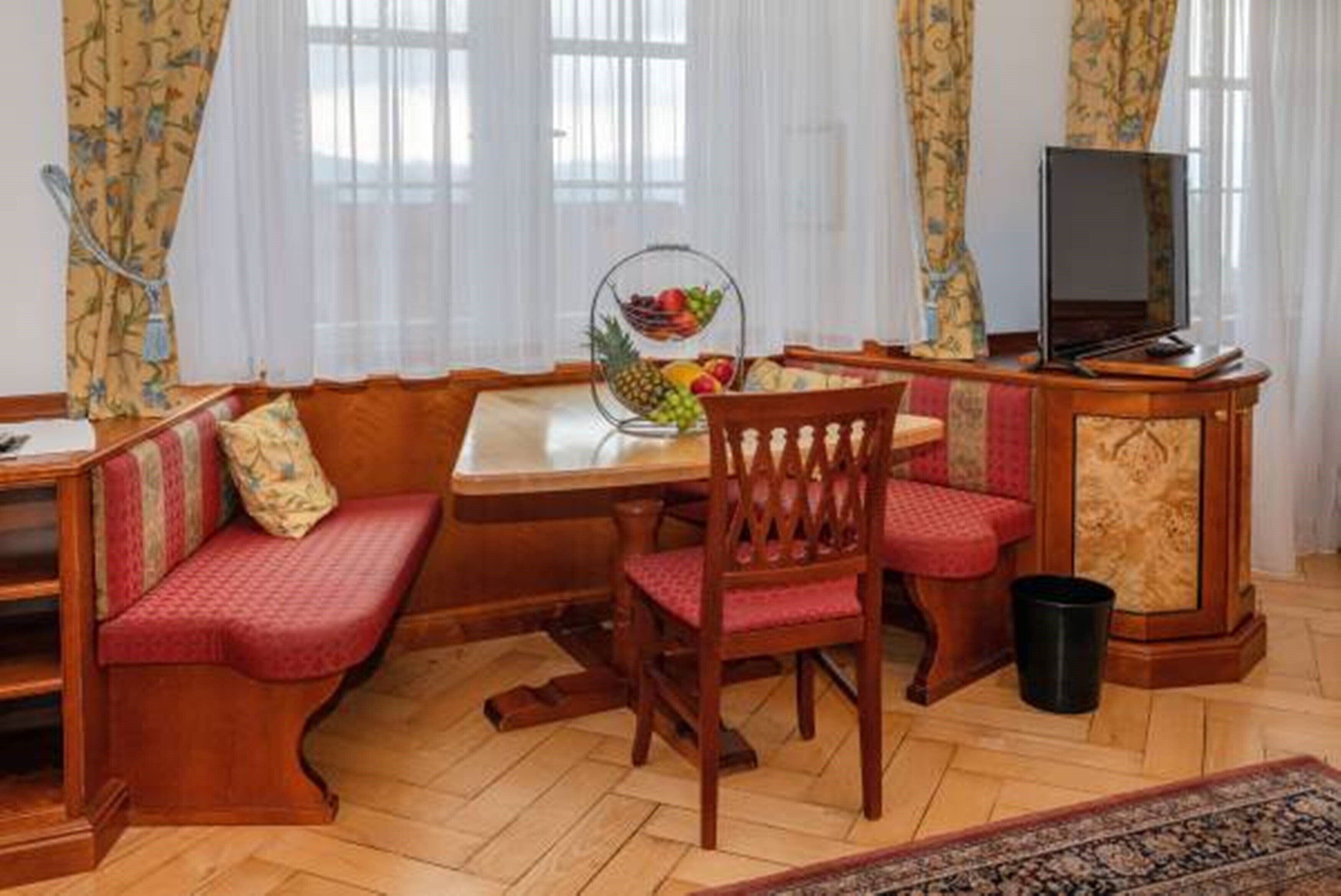 A cozy room with a wooden bench, a round table, and a television.