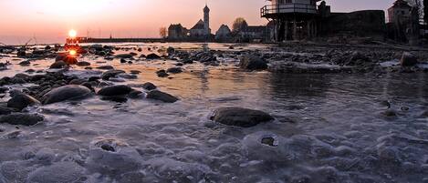 A river with rocks and a tower structure in the background.