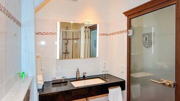 A modern bathroom with a black countertop sink, a mirror, and a glass shower enclosure.