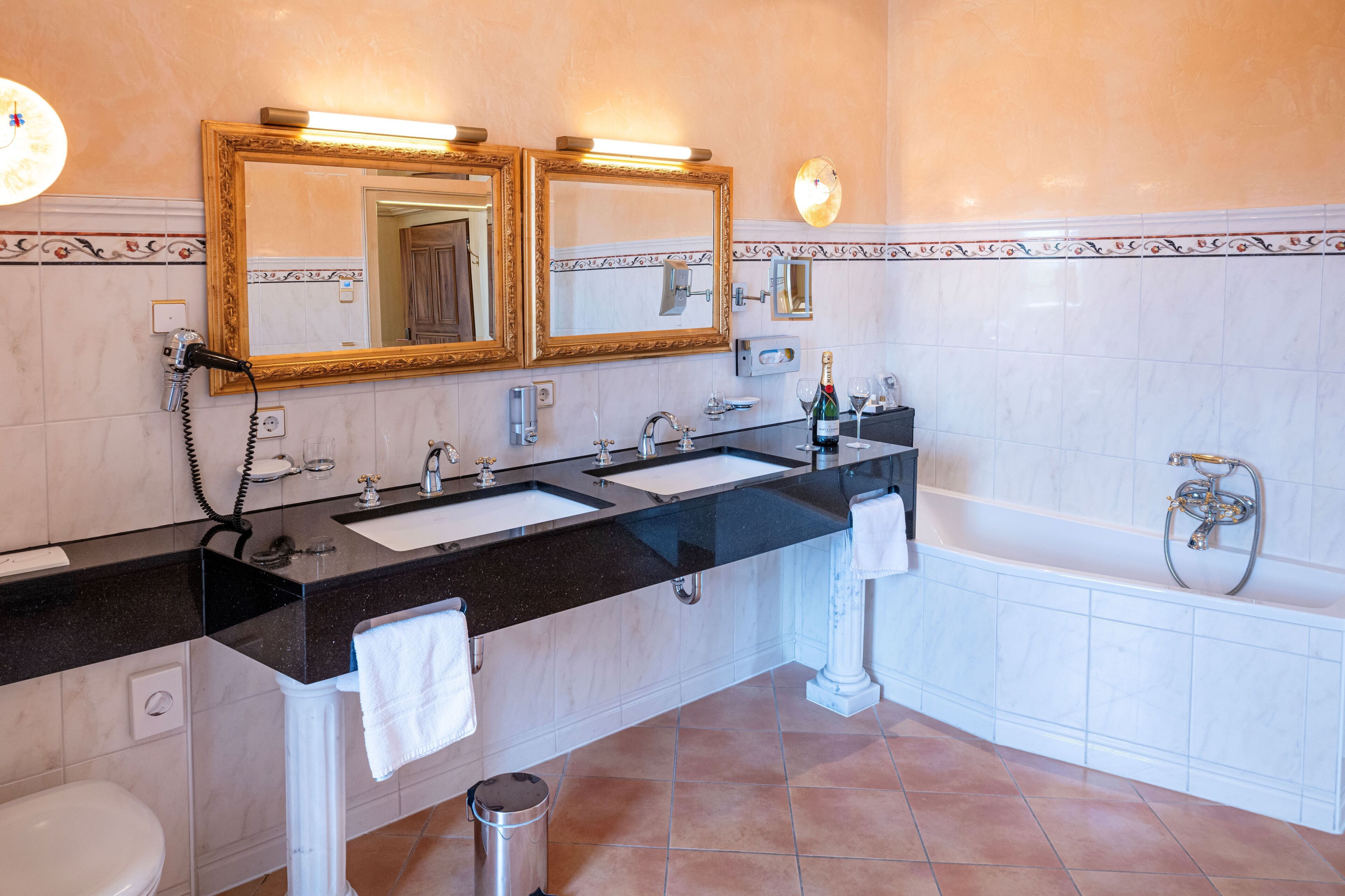 Ein Badezimmer mit zwei Waschbecken, einer Badewanne und einer Toilette.