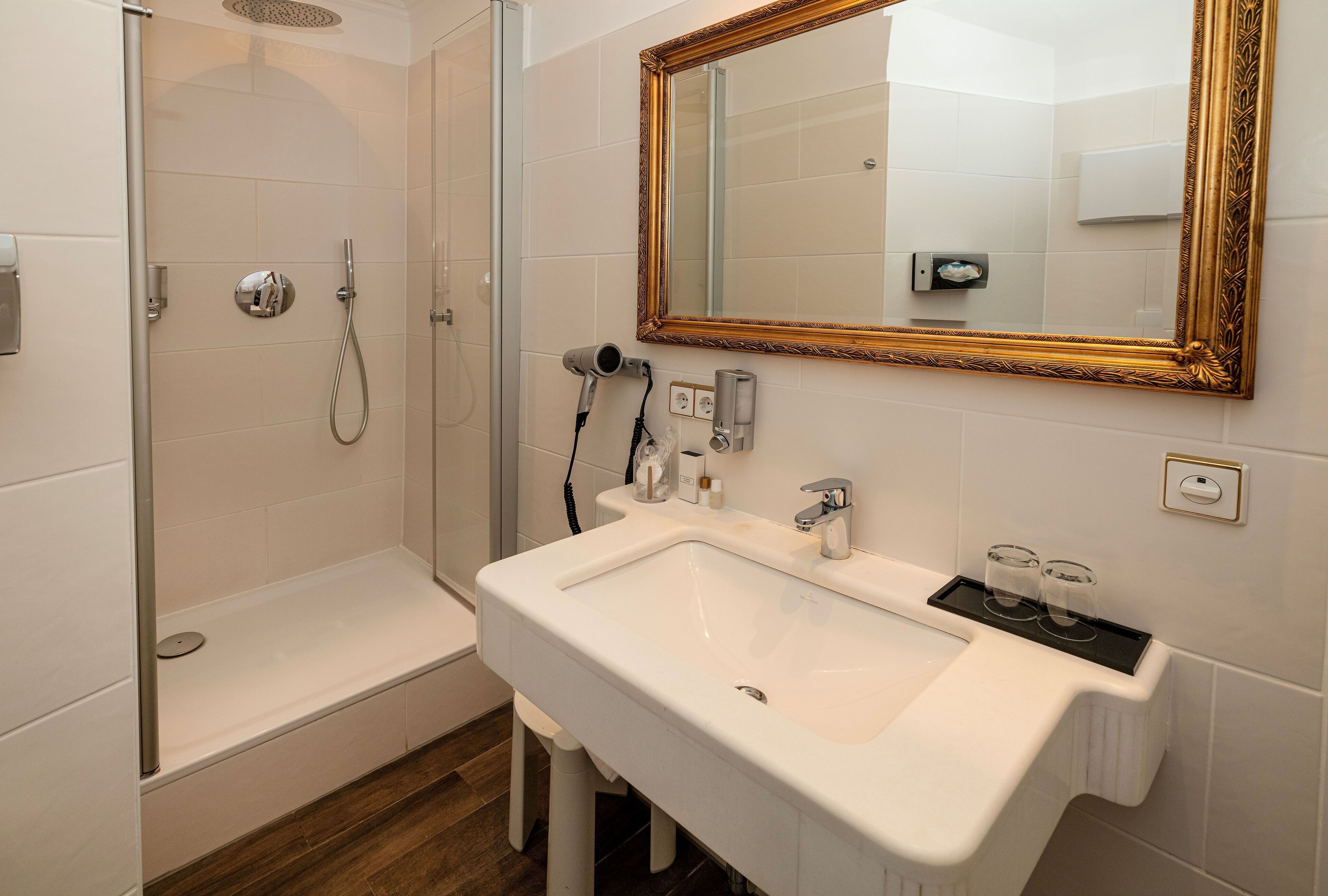 A bathroom with a shower, a sink, and a mirror.