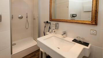 A bathroom with a shower, a sink, and a mirror.