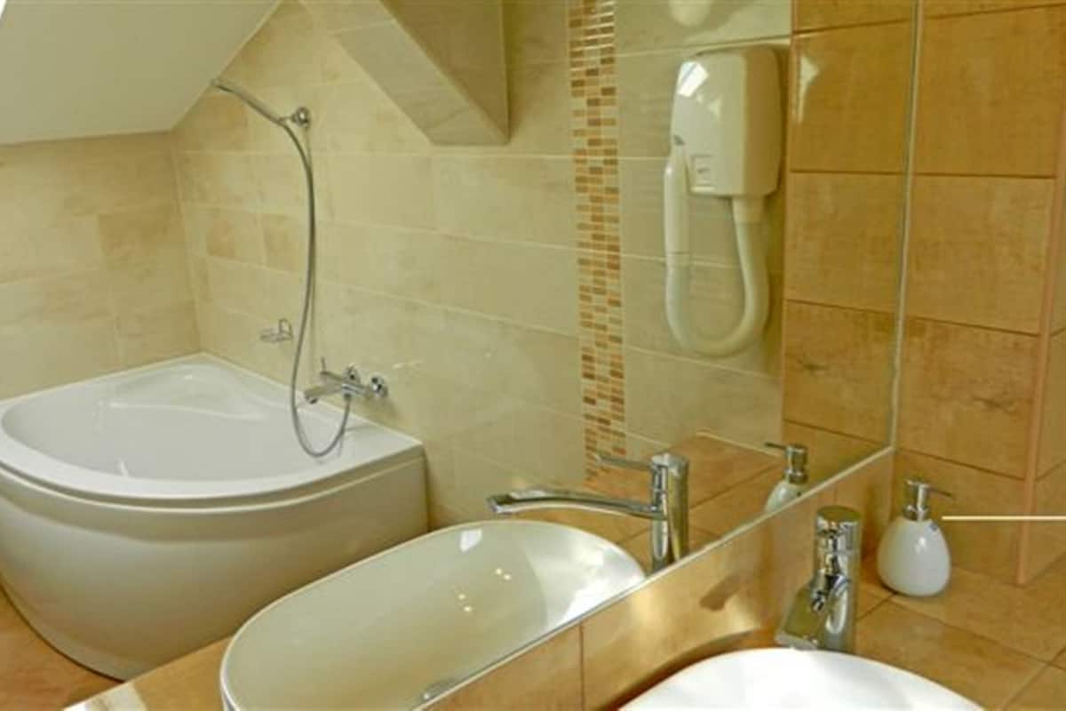 A bathroom with a bathtub, a toilet, and a sink.