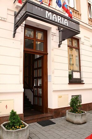 Welcome to Maria, where guests can enjoy a warm entrance with a beautifully designed awning and lush greenery.