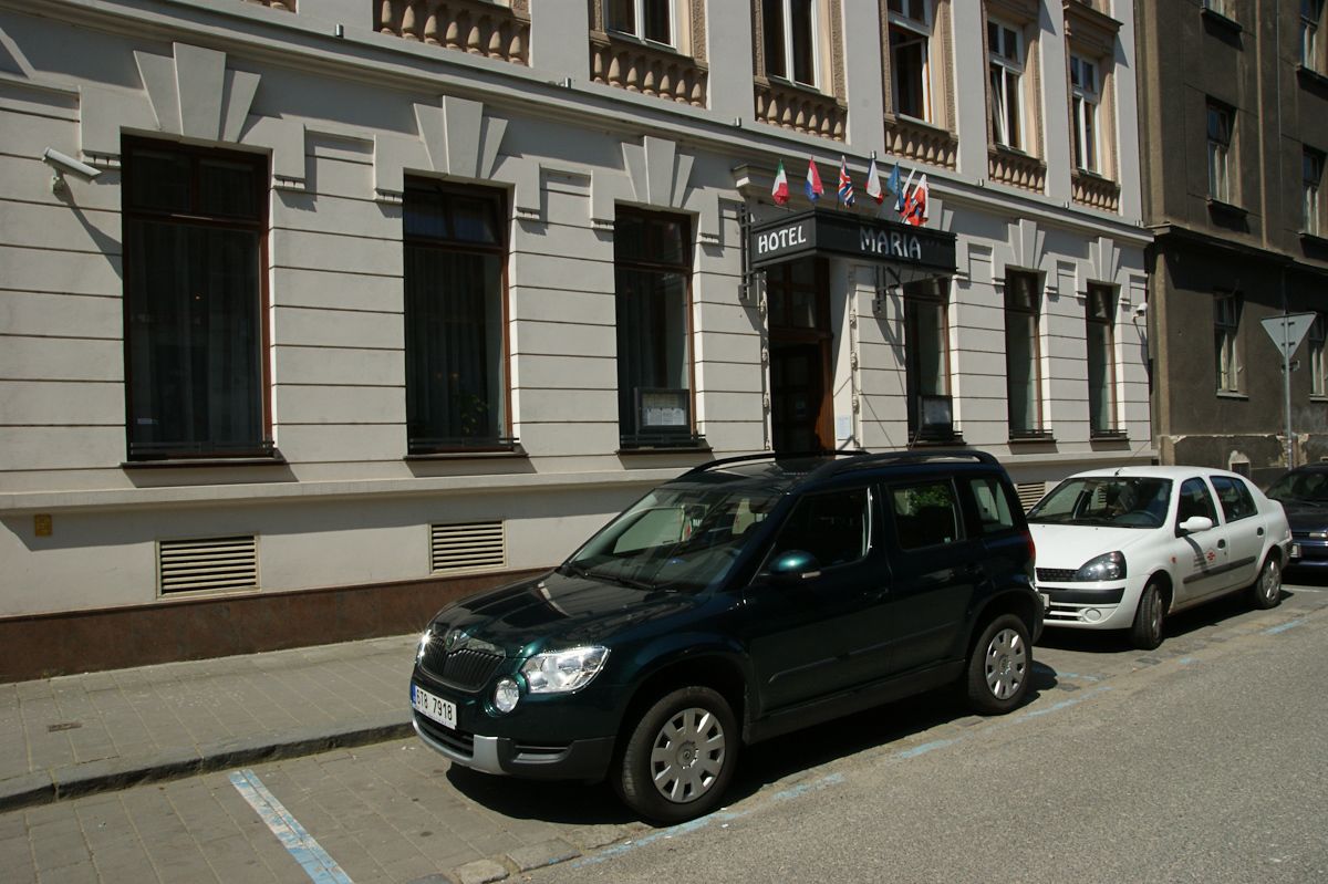 A building with a sign reading "HOTEL MARIA" and flags above the entrance.