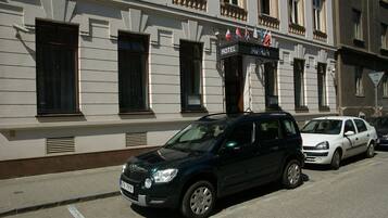 A building with a sign reading "HOTEL MARIA" and flags above the entrance.