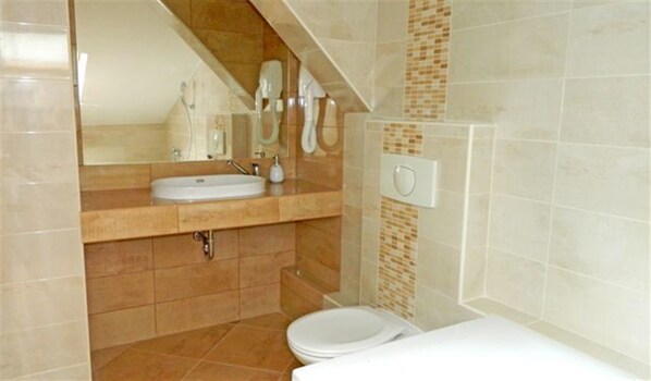 A bathroom with a sink, mirror, and toilet. - Hotel Maria (Ostrava)
