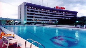 Un hotel con piscina, varios pisos y un cartel que dice 'ELMI'.