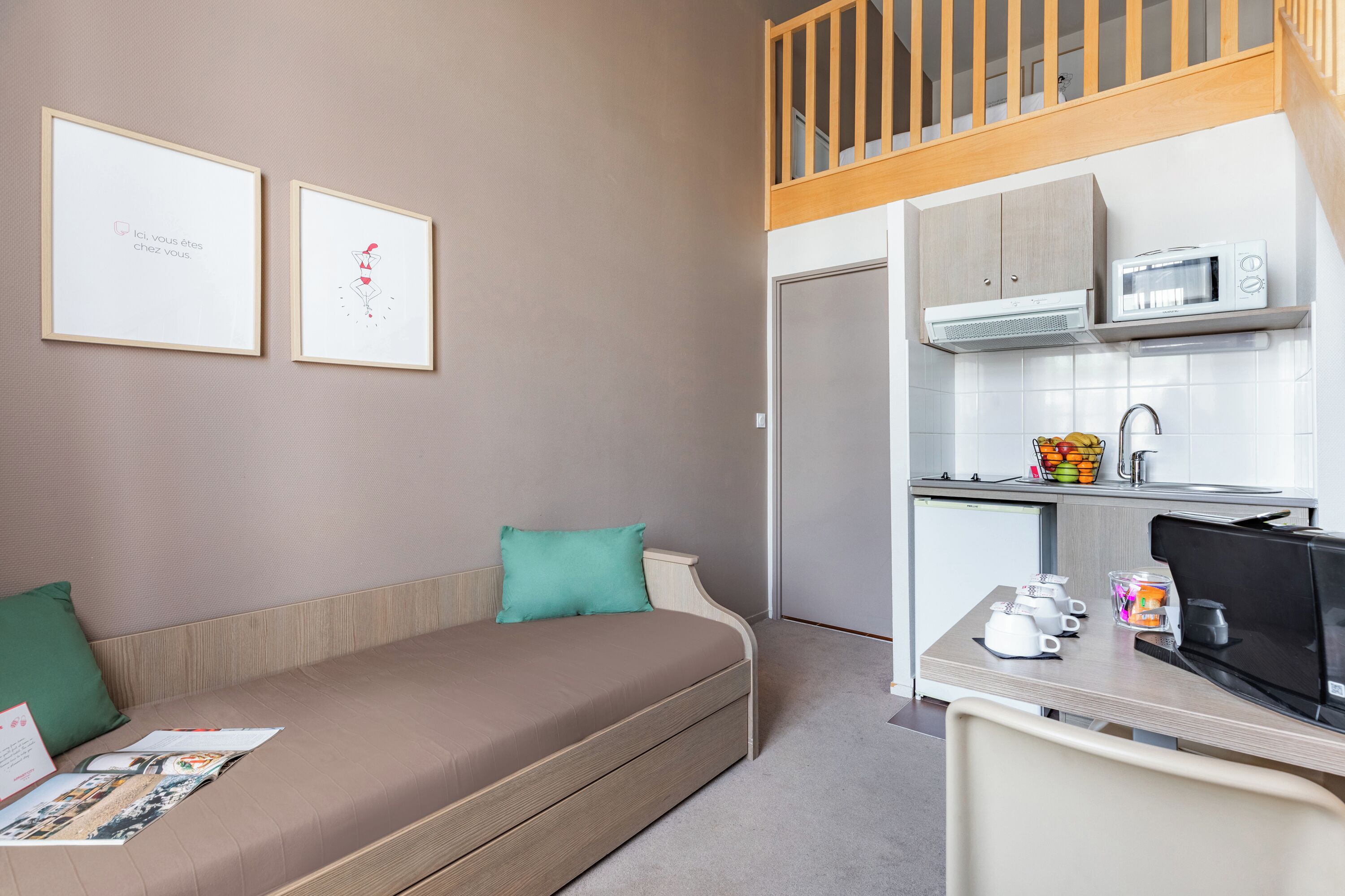 A compact living space with a sofa, a small kitchenette, and a dining area.
