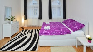 A modern bedroom with a bed, white dresser, and a zebra-patterned rug. - Mivos Prague Apartments Vltava (Prague)
