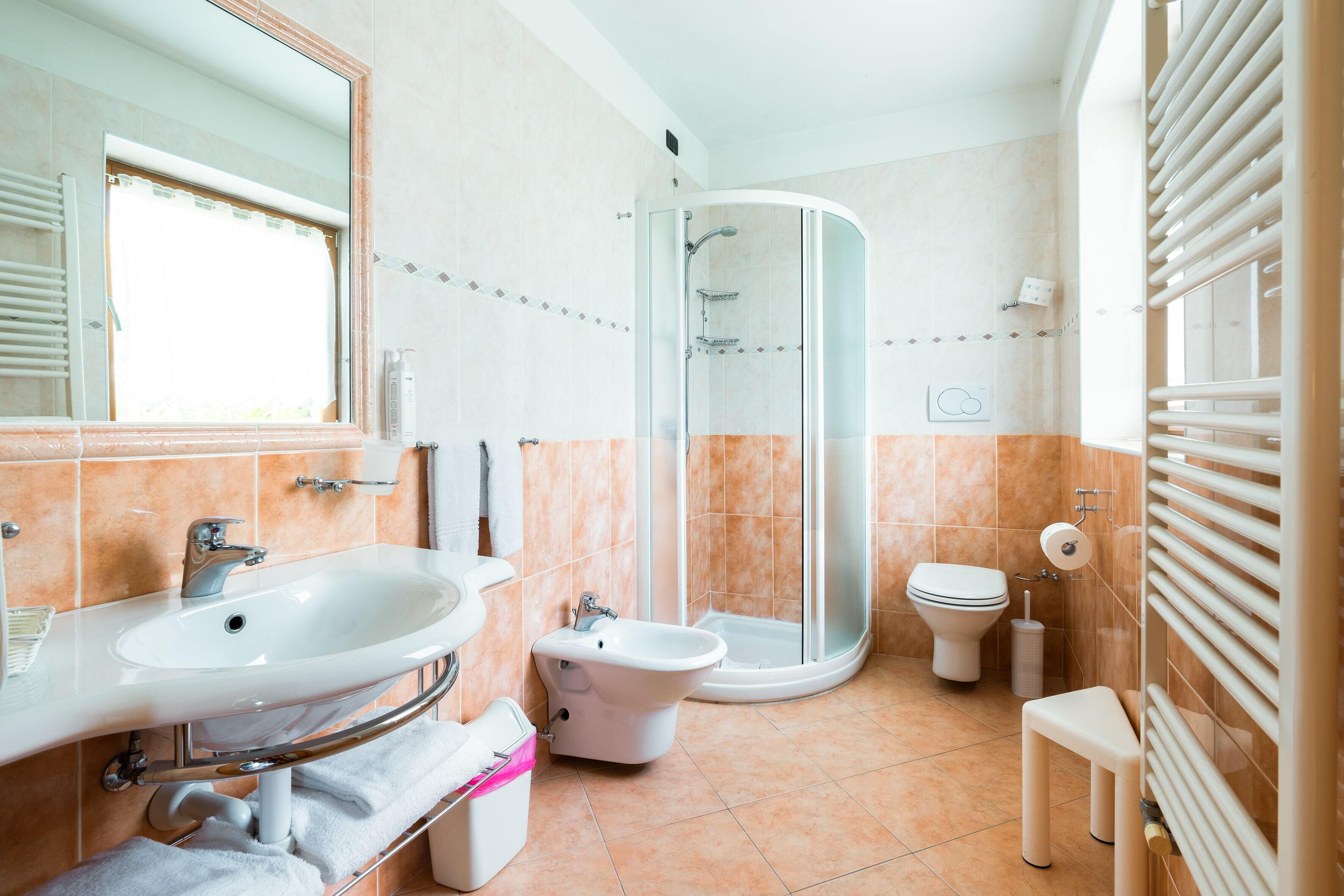 Une salle de bain moderne avec une douche à parois de verre, un lavabo, un bidet et des toilettes.