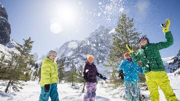 A group of people in a snowy mountainous area with clear skies.