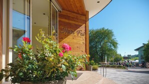 A hotel entrance with a wooden facade and a sign reading "Hotel Fai". - Hotel Fai (Fai della Paganella)