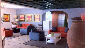 A modern living room with a high ceiling, a large vase, and framed artwork on the wall. - Solar de São João - Apartamentos Turísticos (Albufeira)