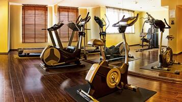 Un gimnasio con bicicletas estáticas, cintas de correr y equipo de ejercicio.