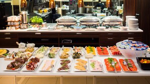 Un bufé con distintos alimentos y utensilios.