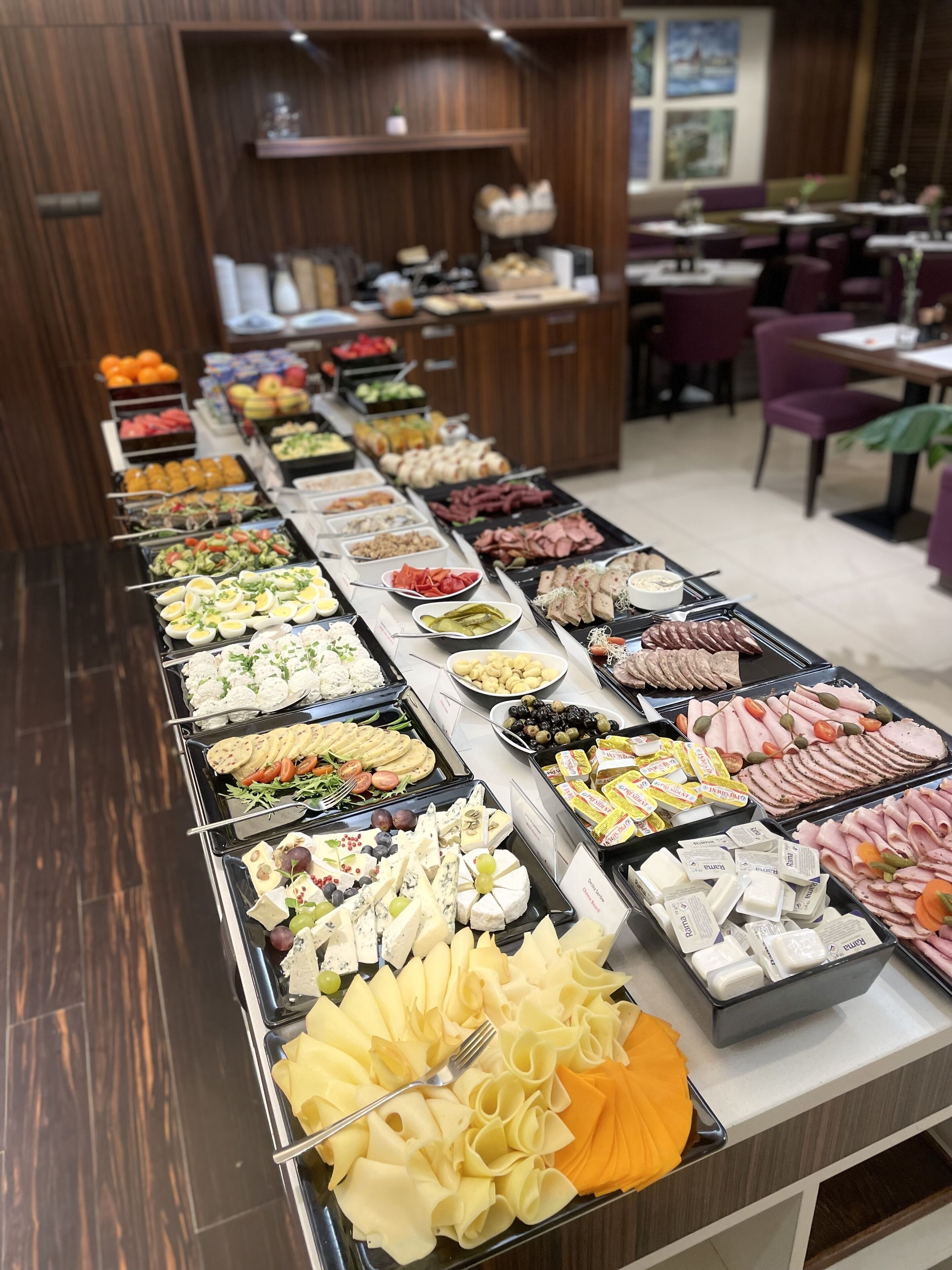 A buffet spread with various food items including fruits, cheeses, and meats.