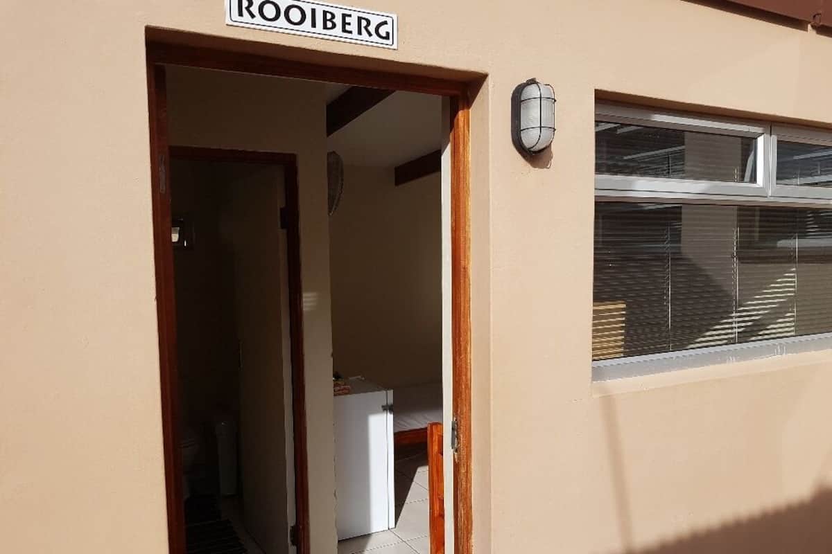 A building entrance with a sign reading "ROOIBERG".
