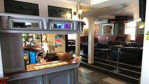 A bar area with a counter, stools, and a fan. - New Union Hotel (Manchester)