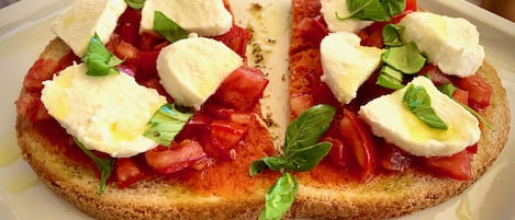 A dish with bread, tomatoes, cheese, and basil.