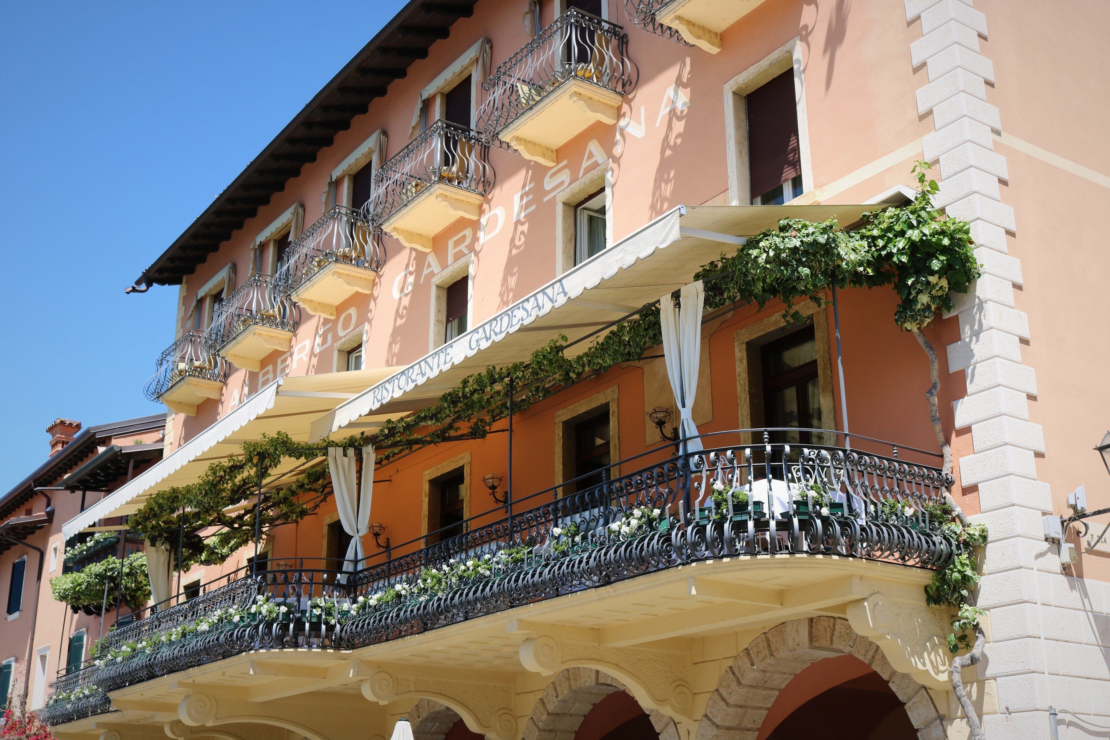 A building with multiple balconies adorned with plants and flowers.