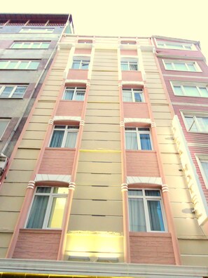 Un edificio de varios pisos con una fachada simétrica, con ventanas distribuidas uniformemente y una banda vertical central.