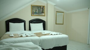 A hotel room with two beds, a painting on the wall, and a mirror. - Tolga Hotel (Istanbul)