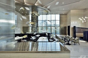 A modern lobby with a central bar, seating area, and large windows. - JW Marriott Mumbai Sahar (Mumbai)