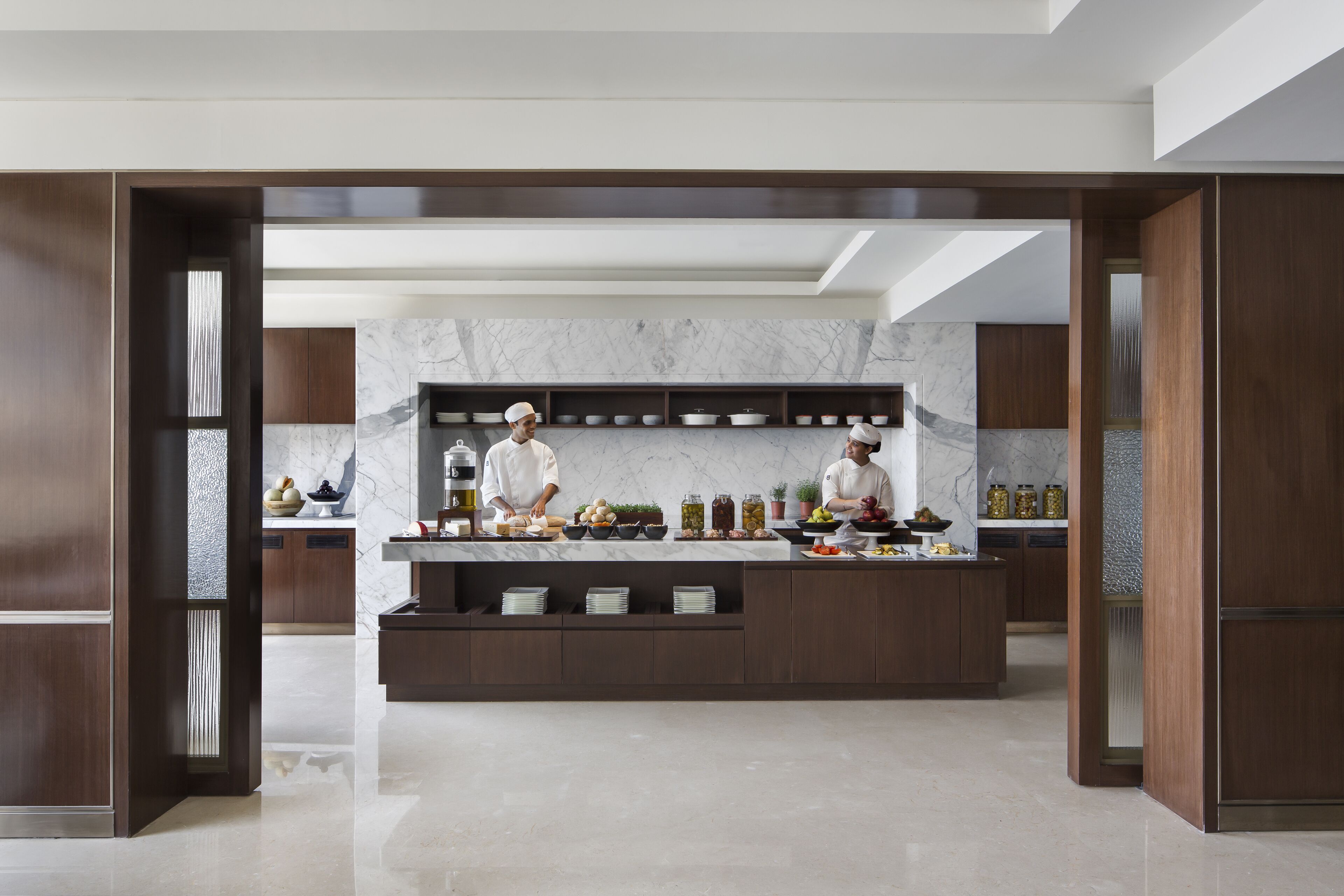 Una cocina moderna con encimeras de mármol, armarios de madera y una isla central.