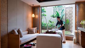 Relax in a serene space with a comfortable sofa, a small table, and a stunning garden view.