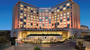 Hotel JW Marriott con fachada moderna, ventanas iluminadas y una entrada bien iluminada.