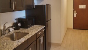 A modern kitchen with dark cabinets, stainless steel appliances, and a granite countertop. - Holiday Inn Express & Suites Golden - Denver Area by IHG (Golden)